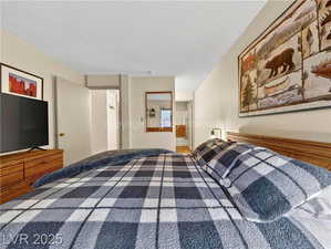 Bedroom with connected bathroom and a textured ceiling