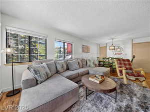 Living area featuring wood finished floors, a textured ceiling, and a chandelier