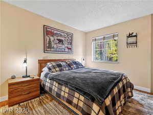 Bedroom featuring wood finished floors and a textured ceiling