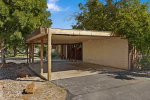 View of parking / parking lot featuring driveway and an attached carport