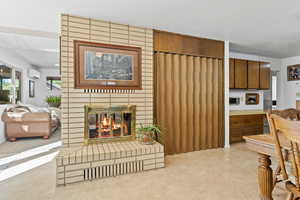 Living room with a fireplace and a wall mounted air conditioner