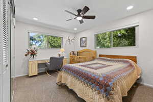 Carpeted bedroom featuring multiple windows, a ceiling fan, a closet, recessed lighting, and a desk