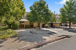 View of front of house featuring asphalt driveway, a carport, a metal roof, and brick siding