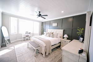 Bedroom featuring a desk, carpet flooring, a decorative wall, a ceiling fan, and wood ceiling