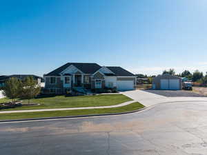 Craftsman house featuring a front yard, a garage, driveway, and board and batten siding