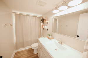 Bathroom featuring shower / bath combo, vanity, and light wood-type flooring