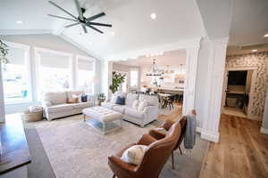 Living area with light wood-style flooring, decorative columns, recessed lighting, and a ceiling fan