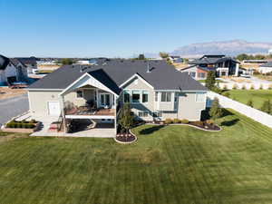 Back of house with a deck with mountain view, a shingled roof, a residential view, and stairway