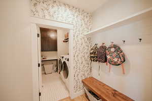 Laundry area with washer and clothes dryer and wallpapered walls