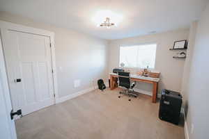 Office with light colored carpet and baseboards