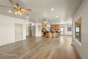 Living room featuring light wood-style flooring, recessed lighting, and ceiling fan