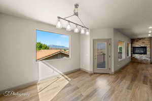 Unfurnished dining area featuring plenty of natural light, wood finished floors, and a textured ceiling