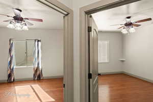 Empty room with a ceiling fan and light wood finished floors