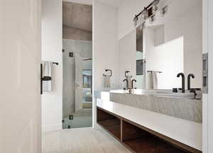 Bathroom featuring double vanity, a shower stall, and light tile patterned flooring