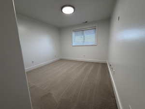 Spare room featuring light colored carpet and baseboards