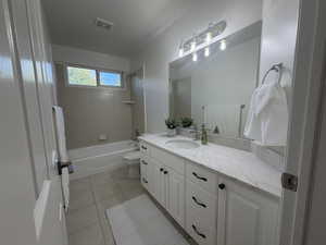 Full bath with  shower combination, light tile patterned floors, and vanity
