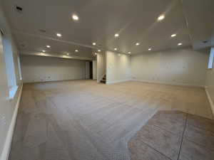 Unfurnished room featuring light colored carpet, recessed lighting, and stairway
