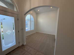 Office with light carpet, recessed lighting, arched entrance.