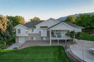 Back of property with a yard, brick siding, and stucco siding