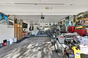 Garage featuring a workshop area and concrete block wall