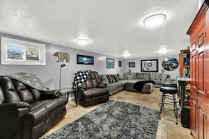 Living room with a textured ceiling and light tile patterned floors