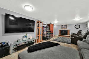 Living room with a textured ceiling, a fireplace, and light tile patterned floors