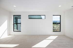 Empty room featuring recessed lighting and light carpet