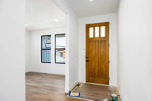Foyer with light wood-style floors and recessed lighting