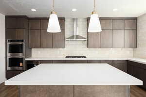 Kitchen with dark wood-style floors, a center island, modern cabinets, wall chimney exhaust hood, and appliances with stainless steel finishes