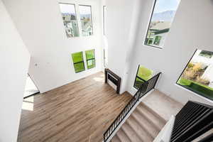 Stairs featuring a towering ceiling and wood finished floors