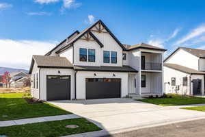 Modern inspired farmhouse with board and batten siding, a front yard, and roof with shingles