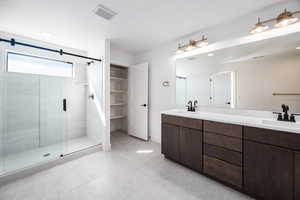 Full bathroom featuring double vanity, a shower stall, and light tile patterned floors