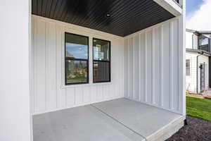 Doorway to property with board and batten siding and a patio