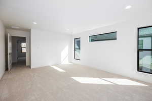 Empty room with recessed lighting and light carpet