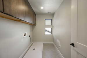 Washroom featuring cabinet space, light tile patterned floors, hookup for an electric dryer, and washer hookup