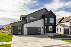 View of front facade featuring a front lawn, driveway, and a mountain view