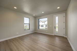 Entrance foyer featuring recessed lighting, light wood-style flooring, and a textured ceiling