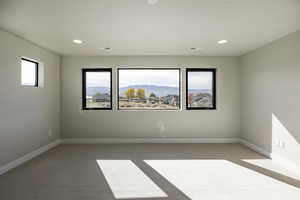 Spare room with light carpet, a mountain view, healthy amount of natural light, and recessed lighting