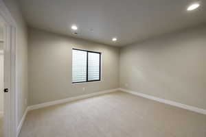 Unfurnished room with light colored carpet and recessed lighting