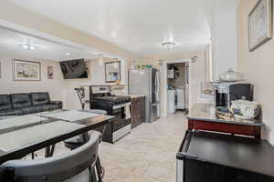 Kitchen featuring stainless steel appliances, light stone counters, open floor plan
