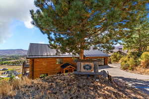 View of front of house featuring a metal roof, a mountain view, and driveway