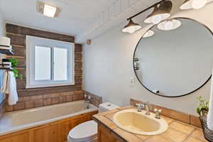 Full bathroom featuring a garden tub, vanity, and wooden ceiling