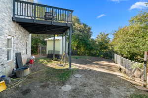 Fenced backyard with a wooden deck and a chicken coop