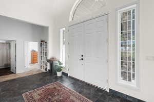 Entryway with a towering ceiling and dark stone finish flooring
