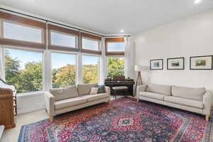 Carpeted living area with recessed lighting and baseboards and wall of windows with $1M views