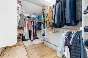 Walk in closet with hardwood floors and a baseboard radiator