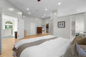 Master bedroom with hardwood flooring, a spacious closet, recessed lighting, ensuite bath, and ceiling fan