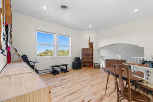 Living/loft space with light hardwood floors, recessed lighting, and baseboard heating