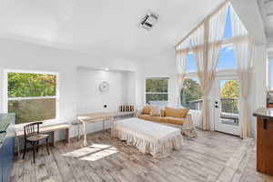Family room with high vaulted ceiling, wood finish floors, and access to amazing deck