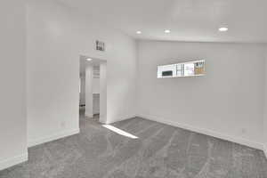 Unfurnished bedroom featuring light colored carpet, recessed lighting, and high vaulted ceiling